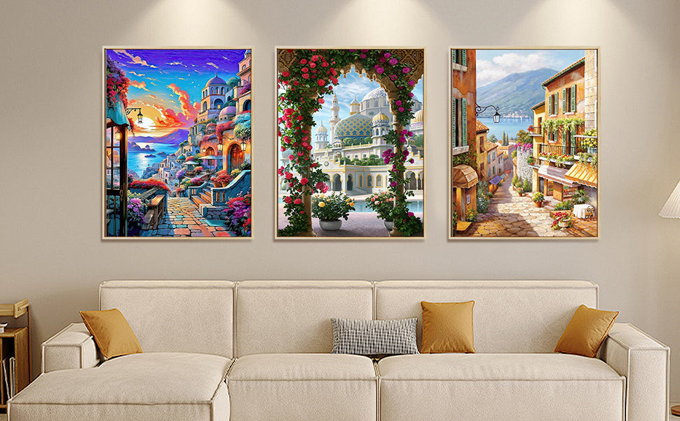 Three framed paint-by-numbers landscape artworks displayed above a sofa, showcasing colorful scenic designs as home decor.